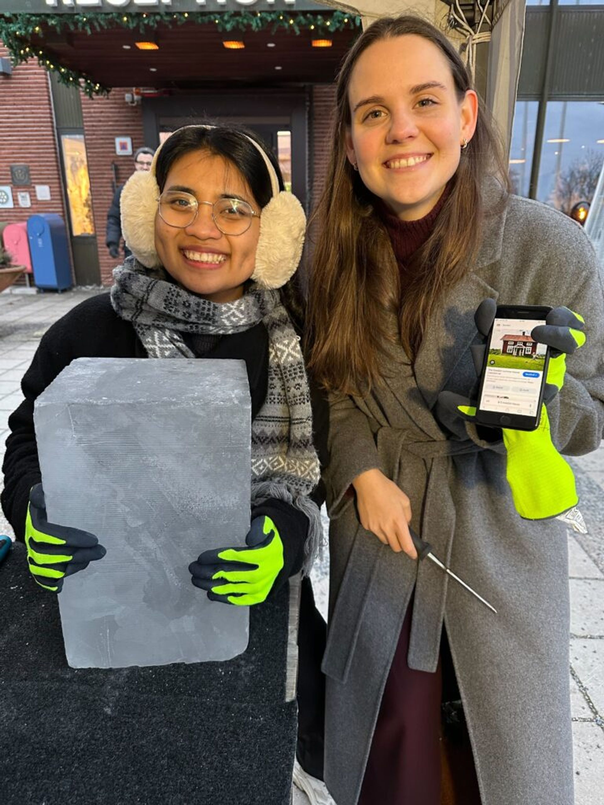 Two girls posing with an ice block.