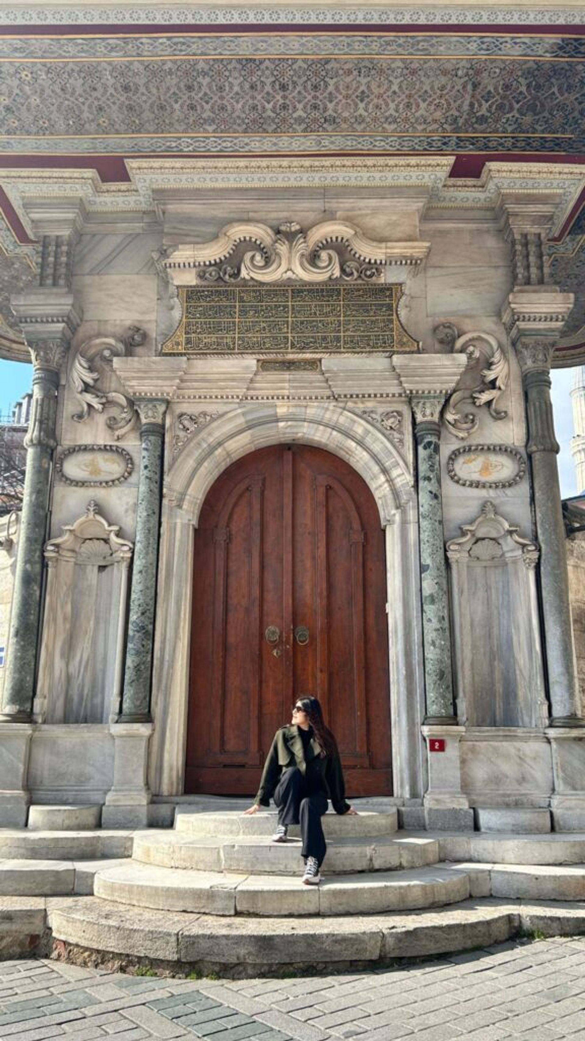 A girl in Turkey in front of a door.