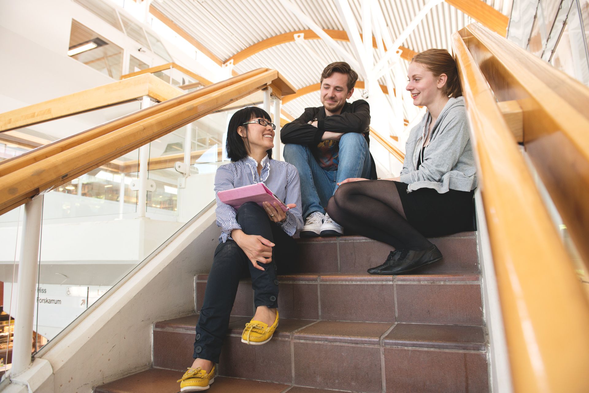 Three students sitting on stairs