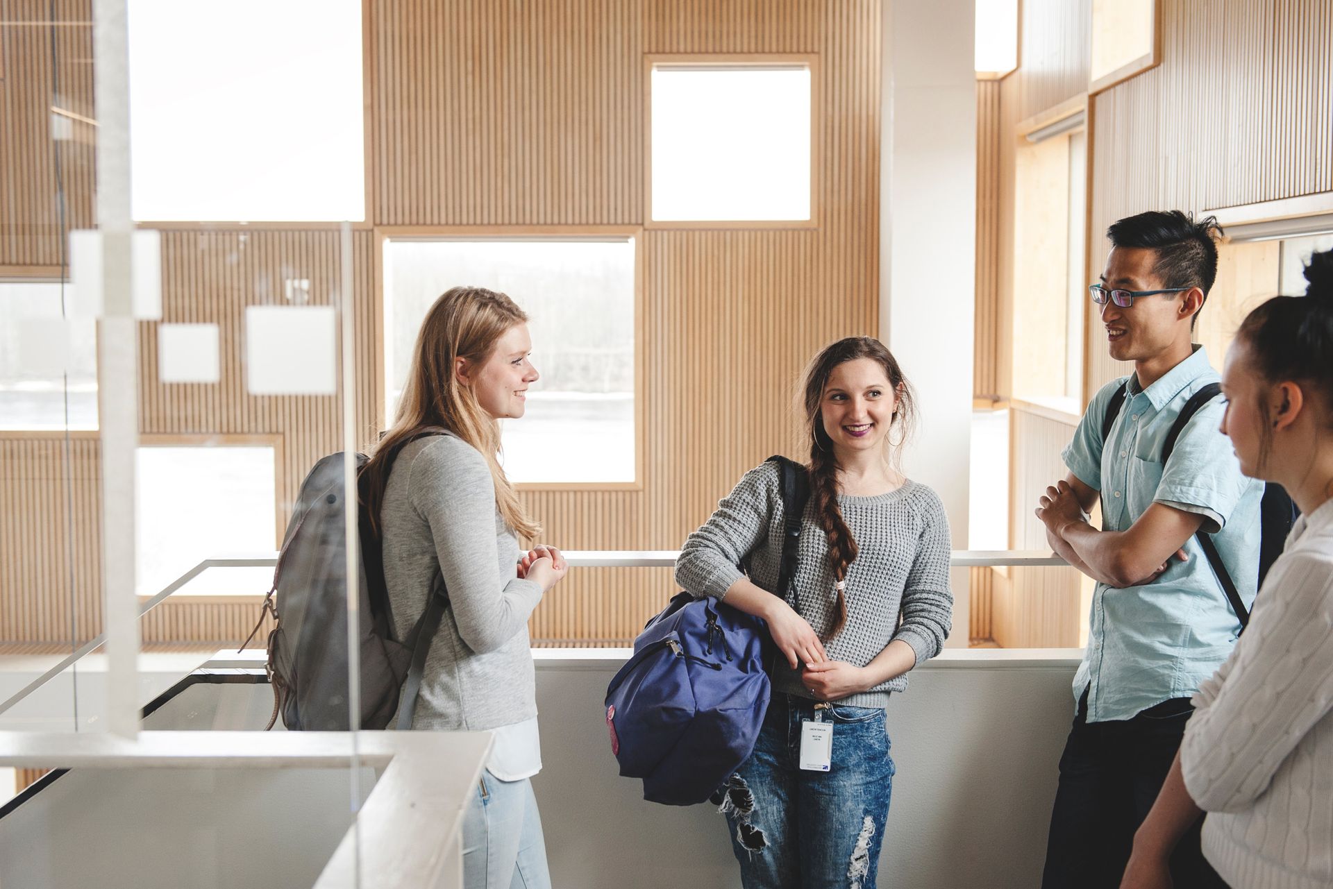 four students talking inside campus