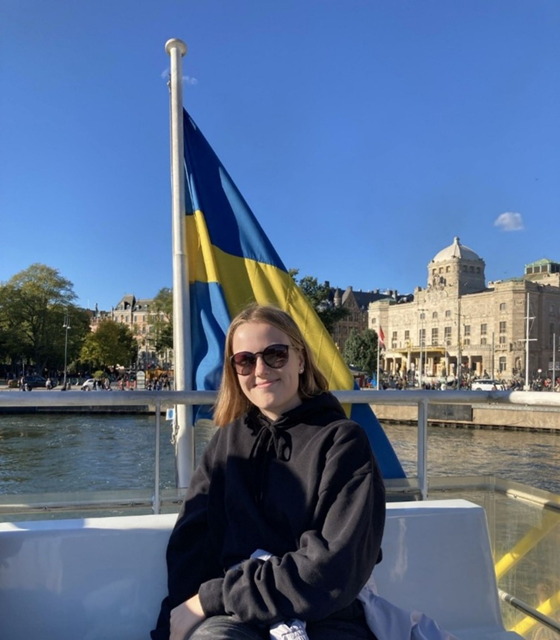 A girl on a boat with a Swedish flag.