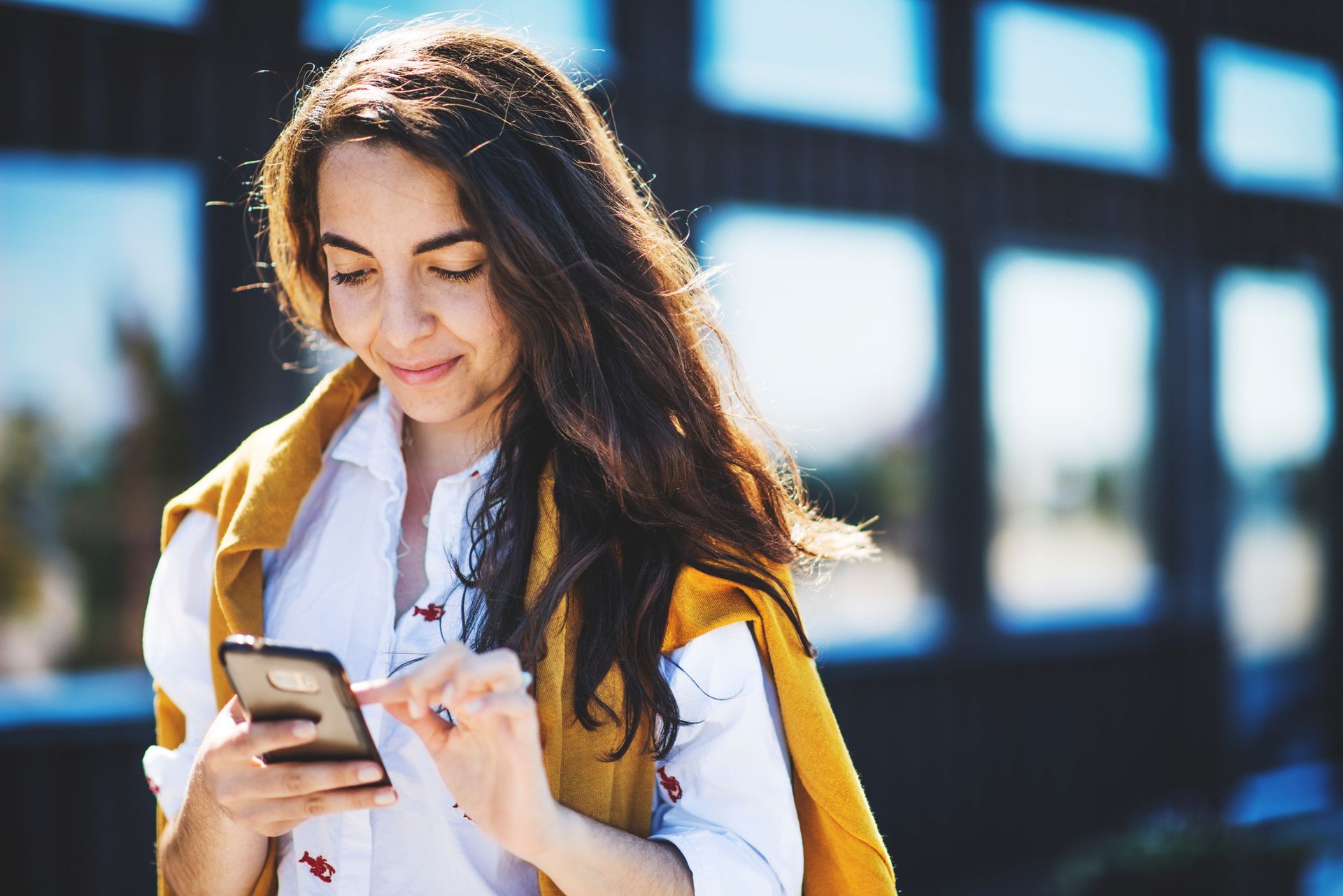 A woman is looking down at her phone.