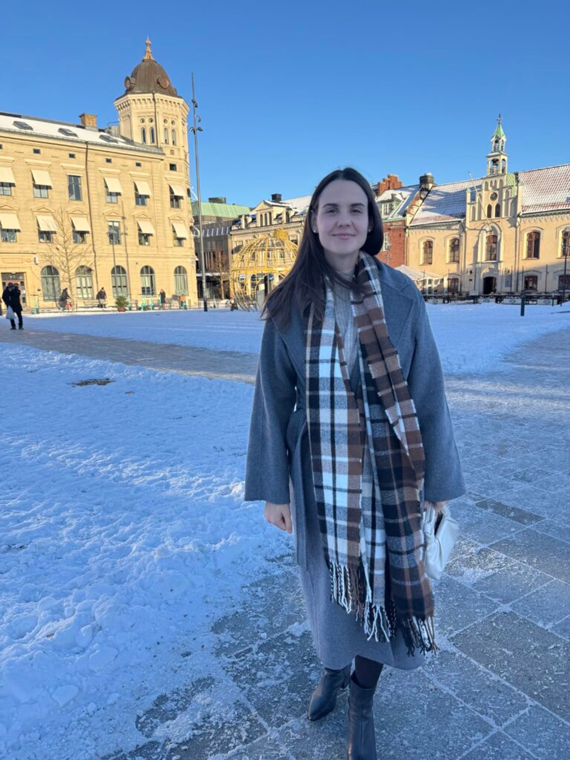 A girl in a winter coat smiling.