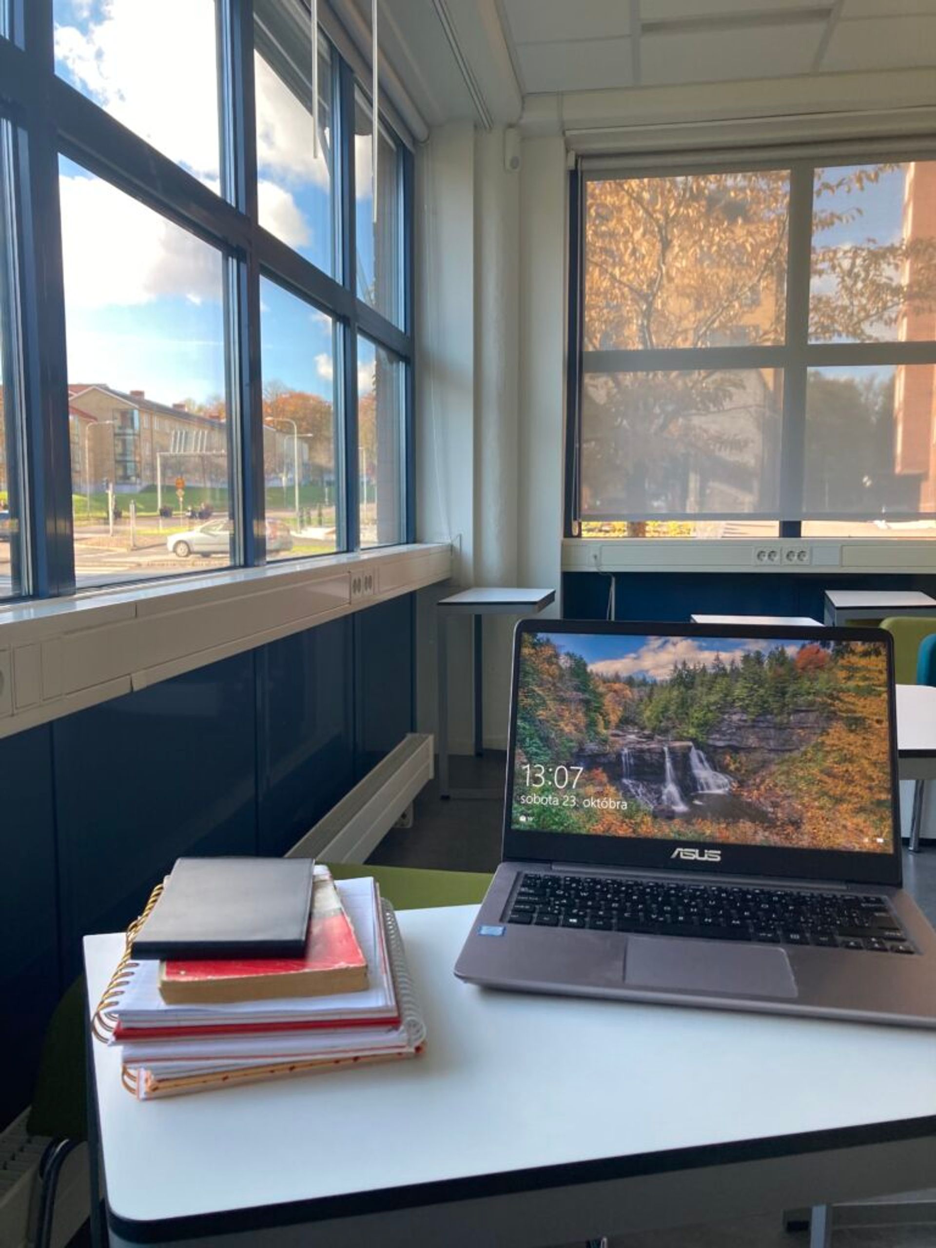 A desk in a library with a computer and books