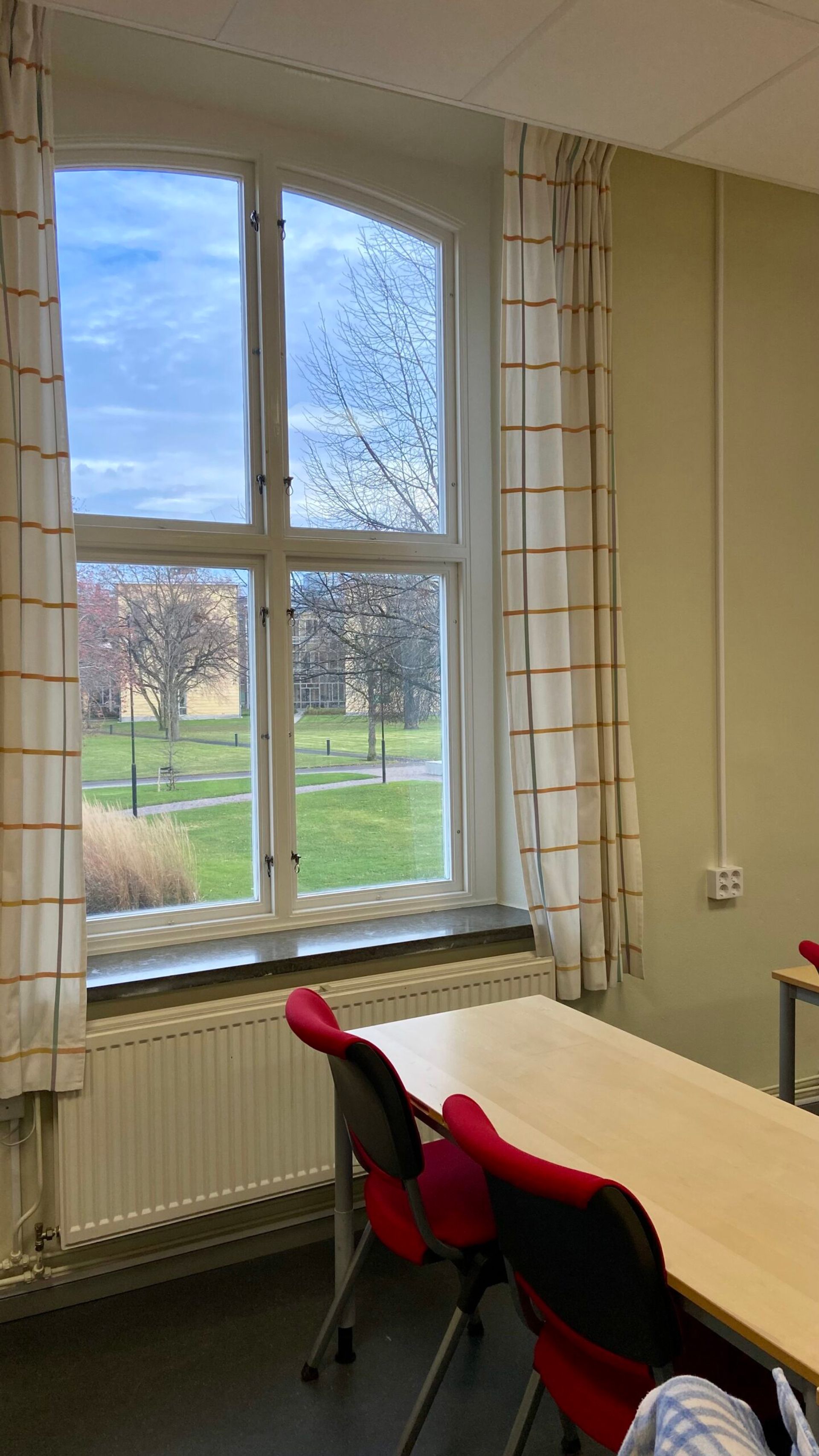 A classroom view with a window looking out to a field