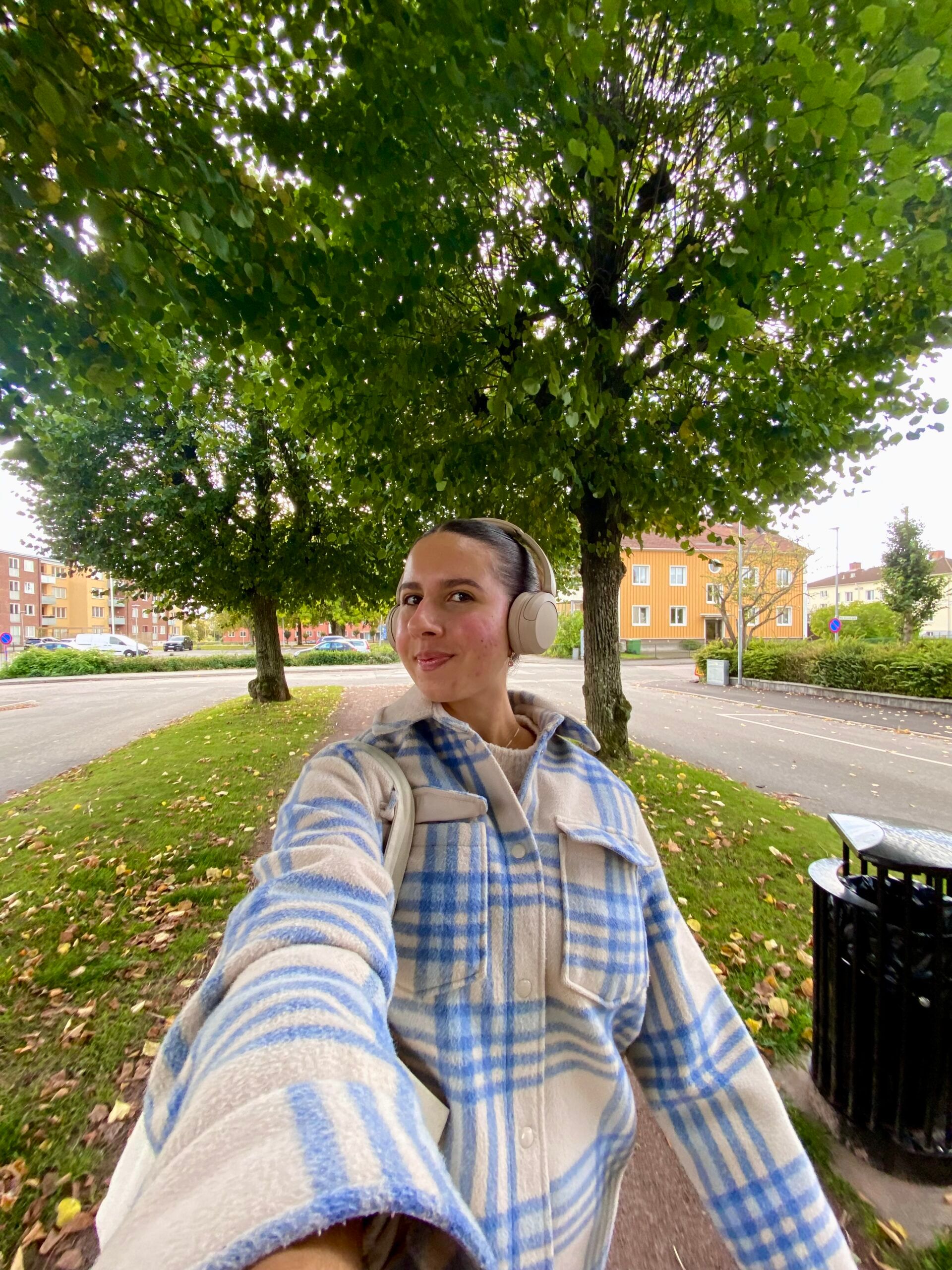 A girl walking under some trees