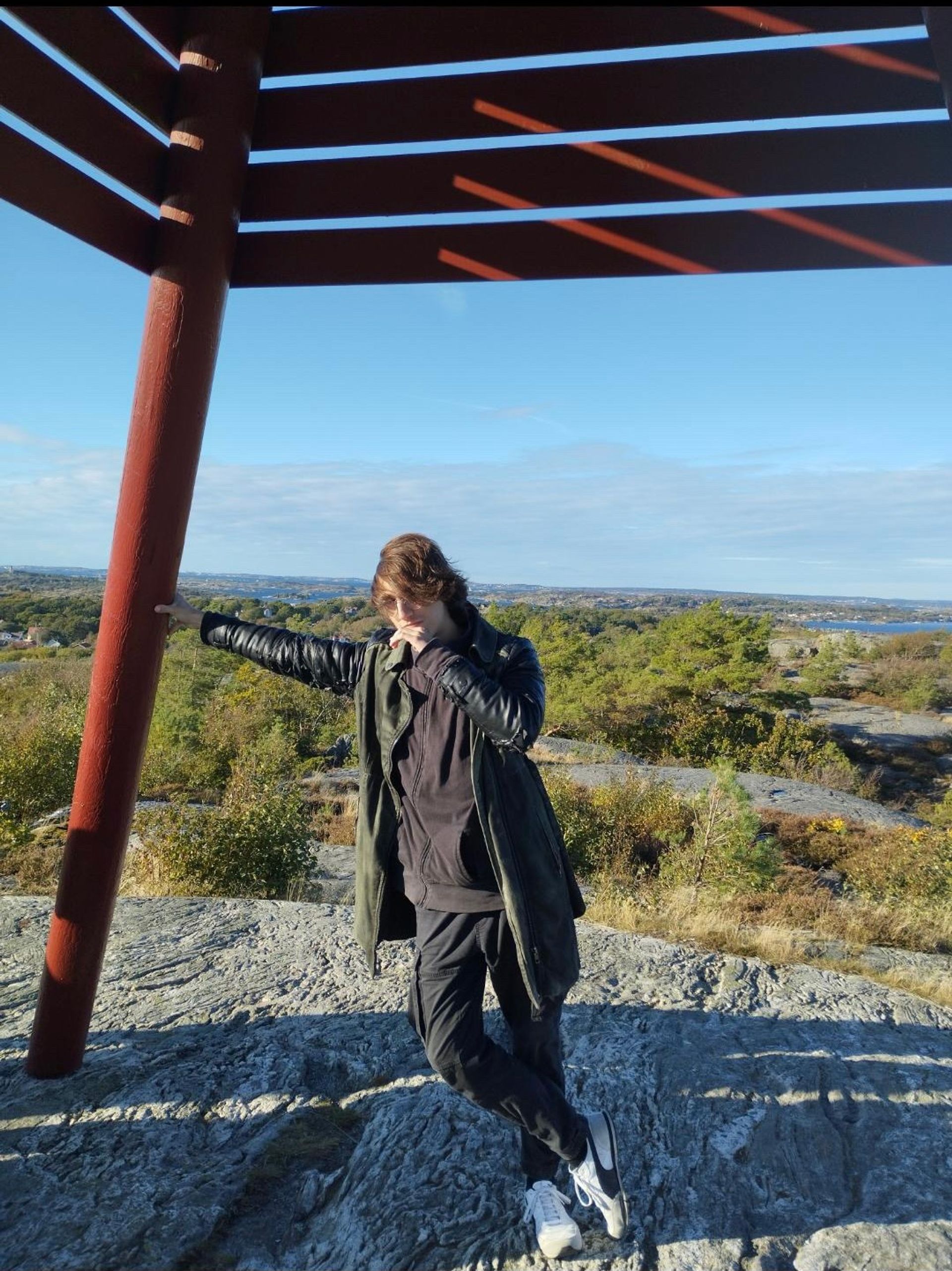 A boy leans against a pole in a Gothenburg island