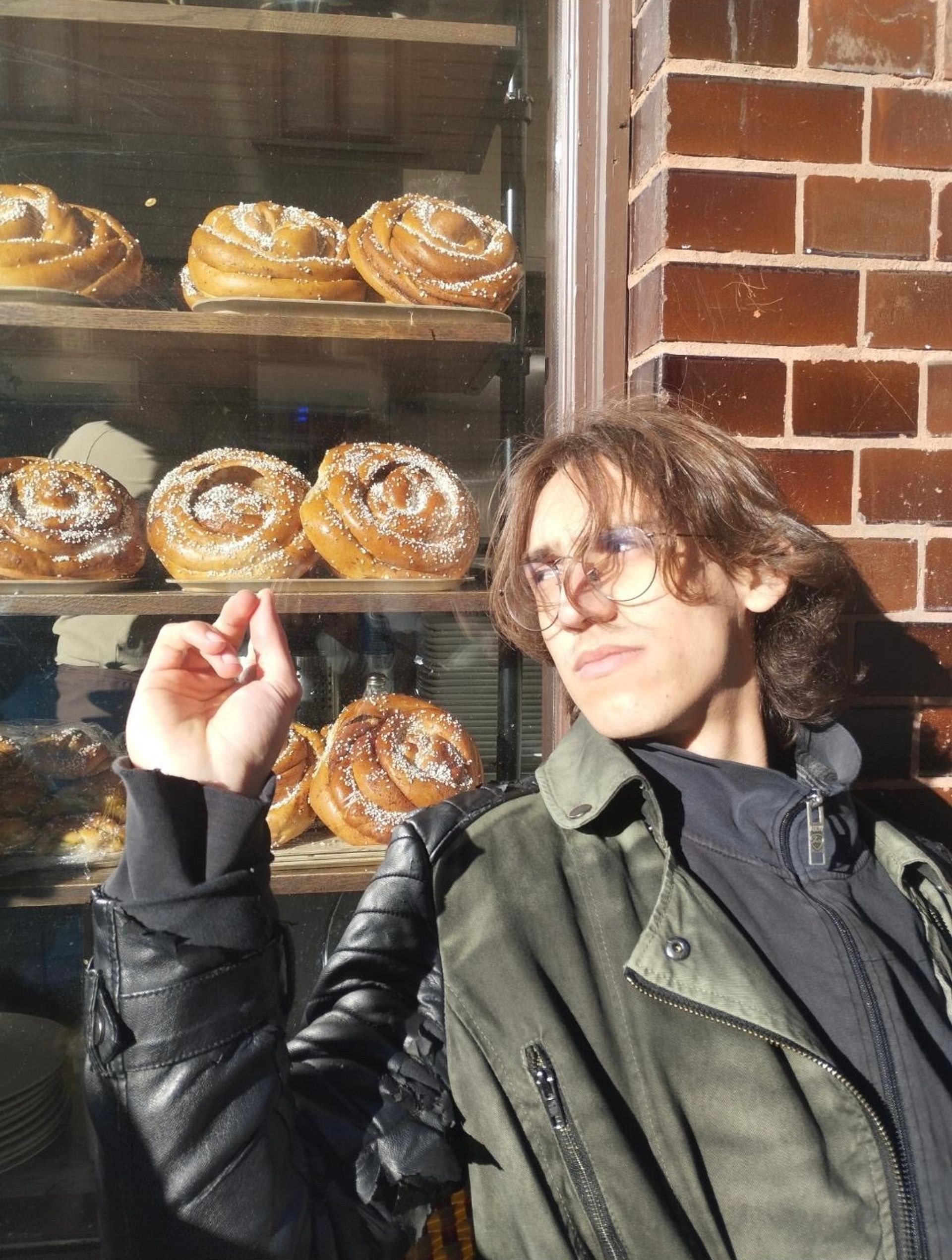 A boy in front of a display of cinnamon buns