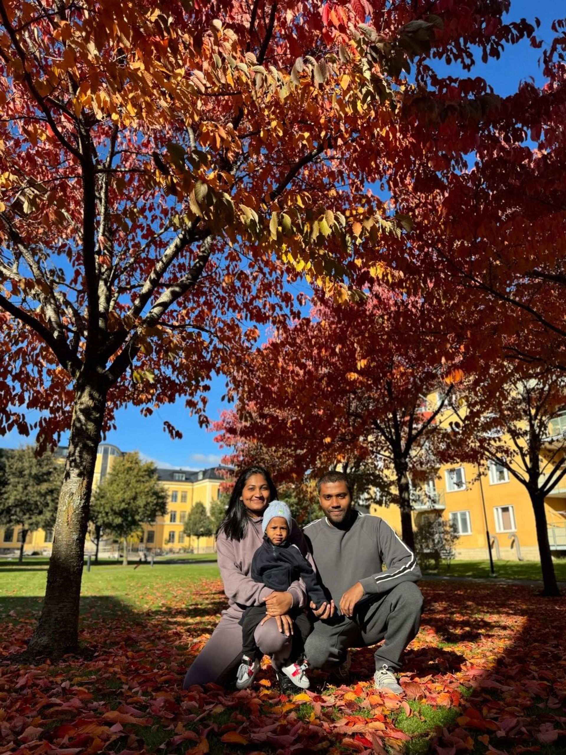 A small family under autumn trees