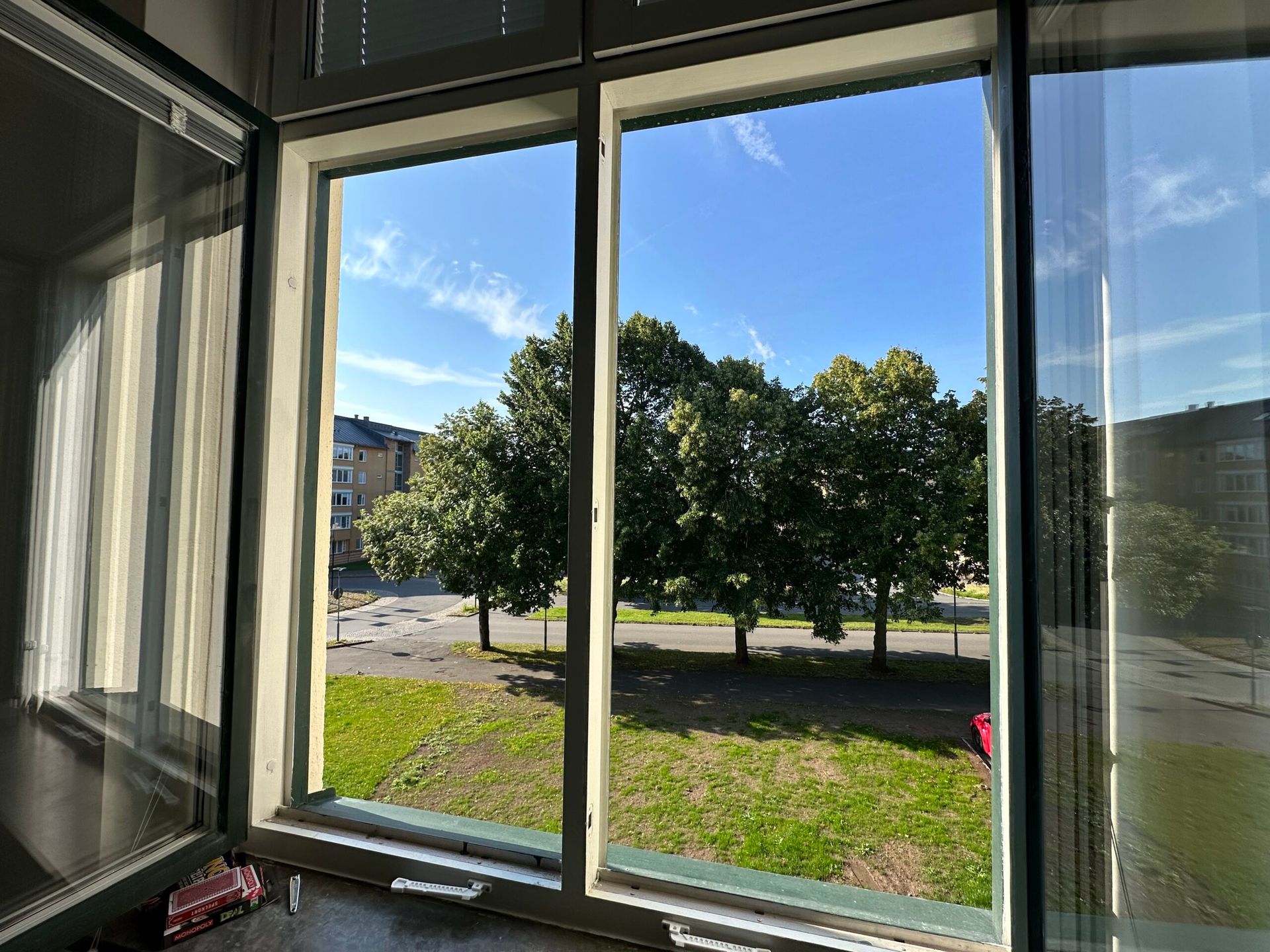 the view of trees through the window of an apartment