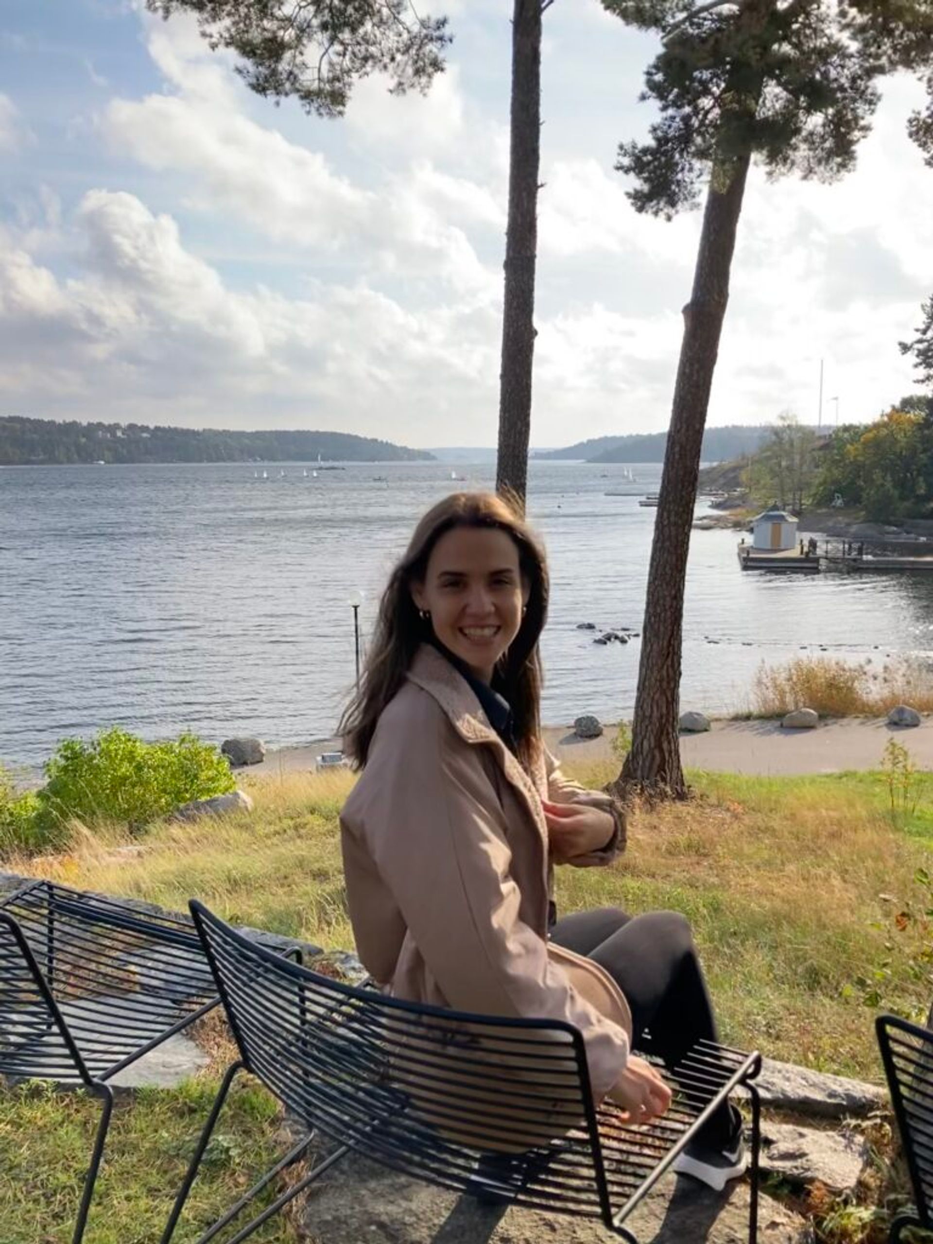 A girl smiling by a lake