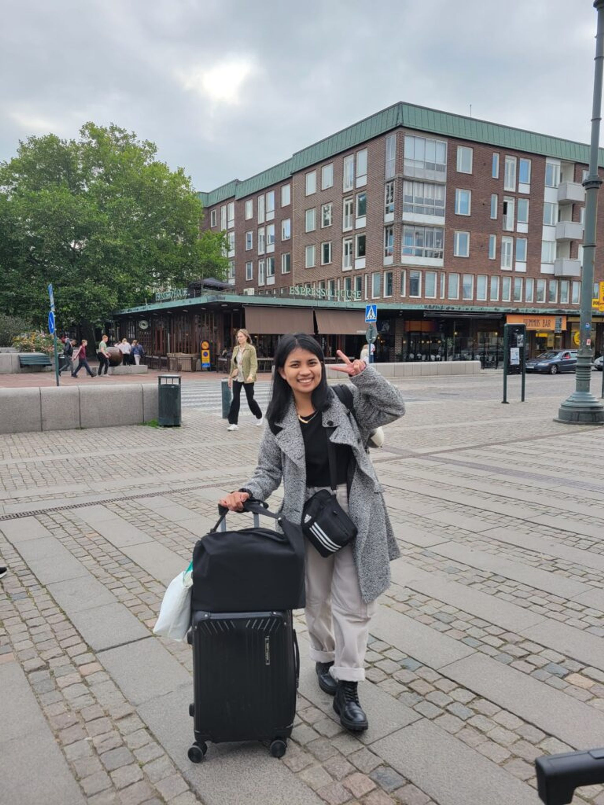 A girl posing with a suitcase.