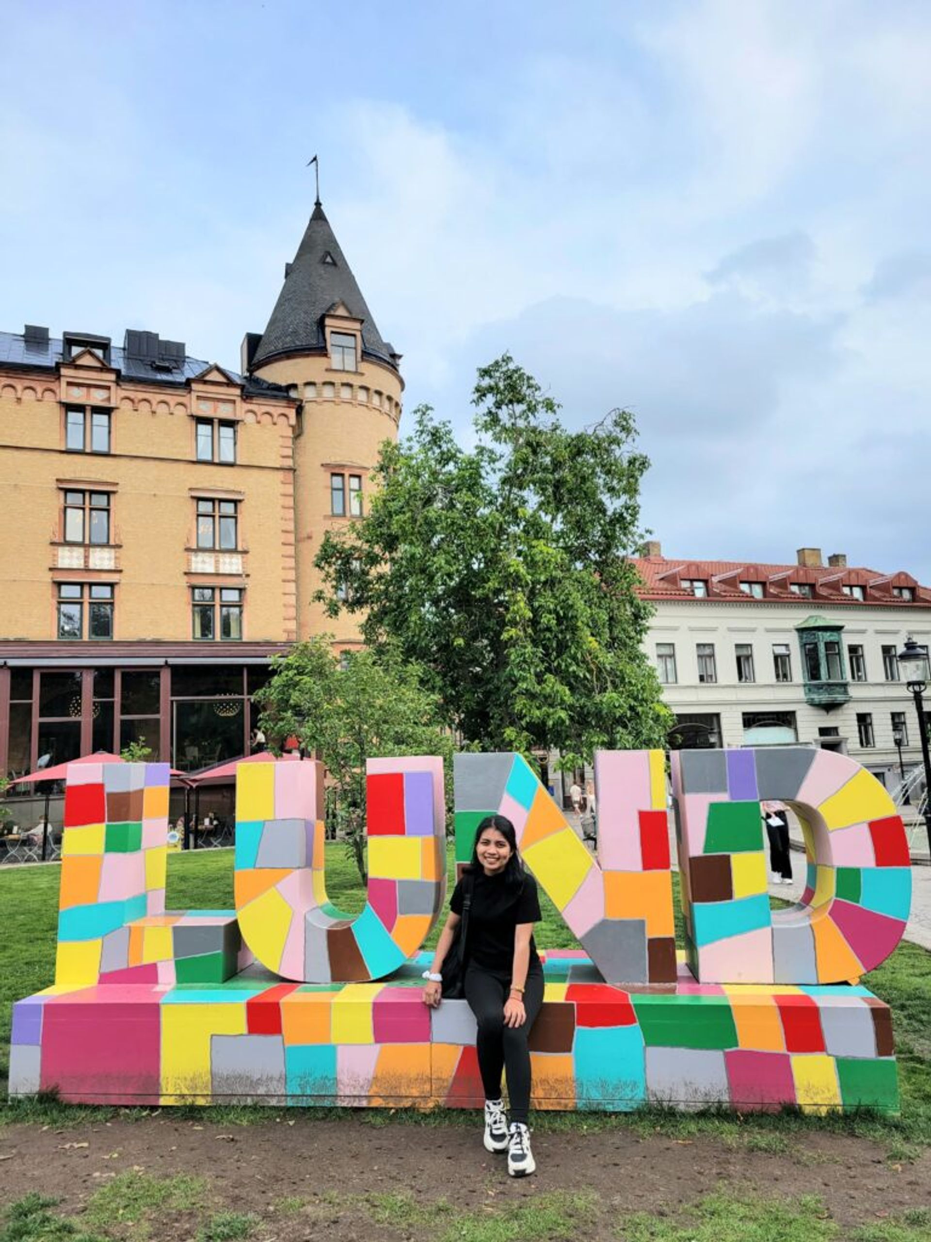A girl posing by a sign Lund.