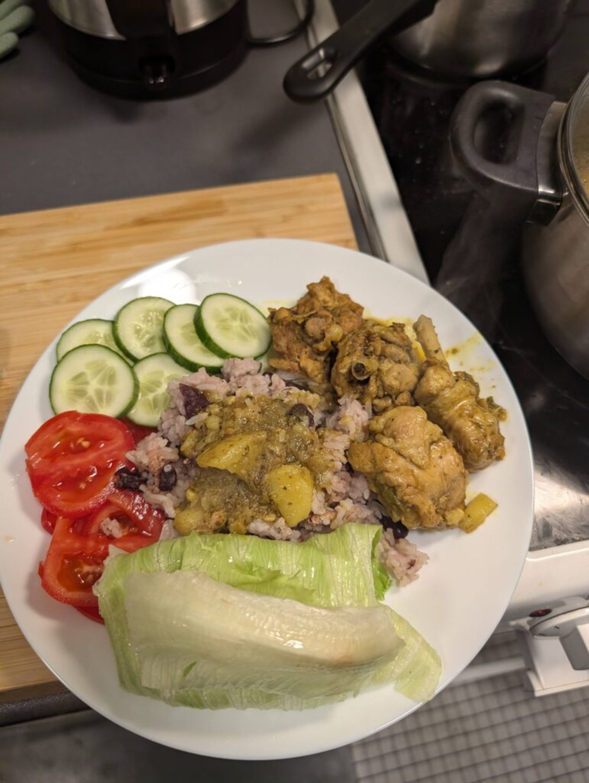 Picture of a plate with traditional Jamaican curried chicken and rice and peas.