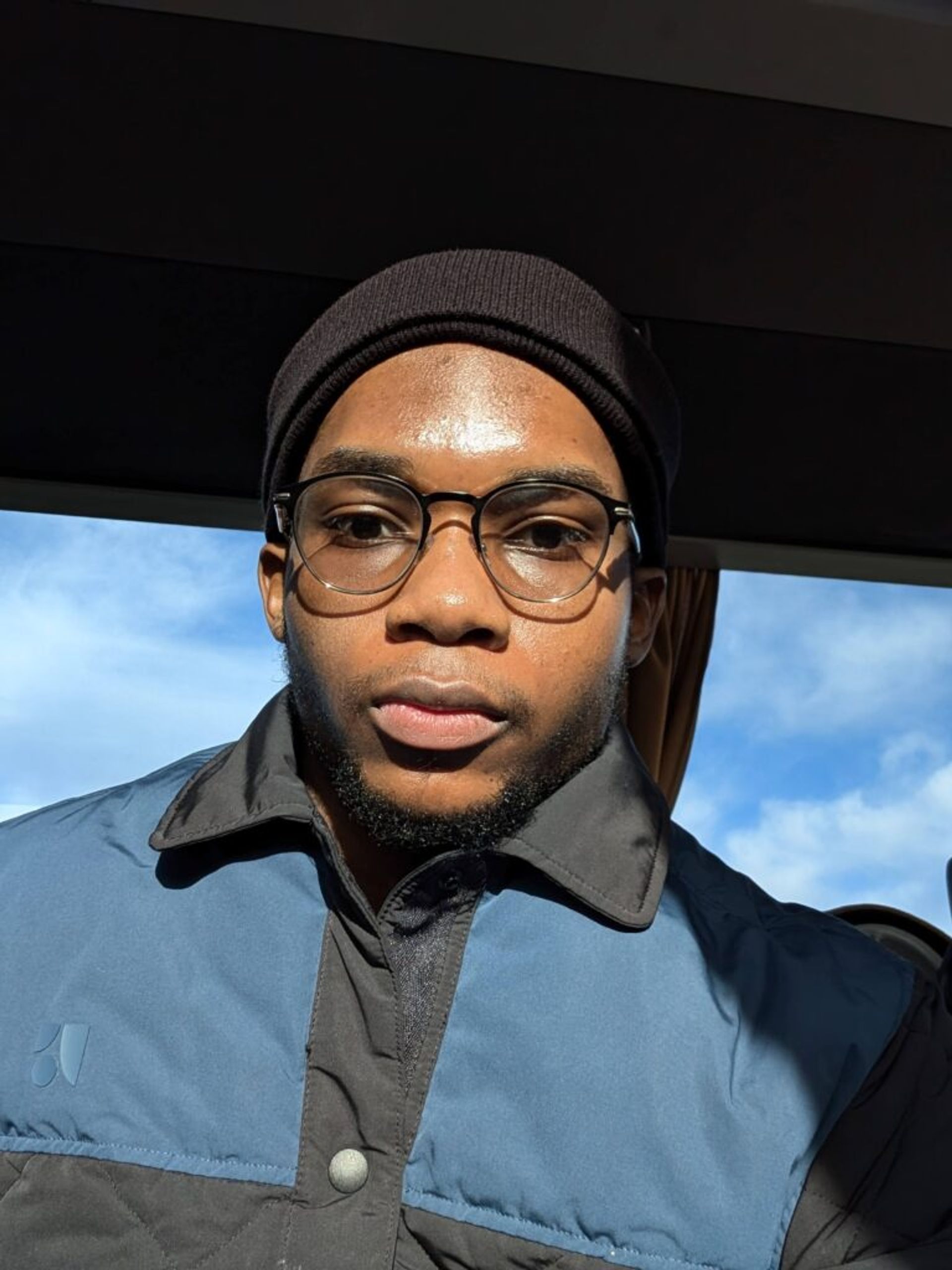 Selfie of Joshua in a blue and black jacket with a beanie.