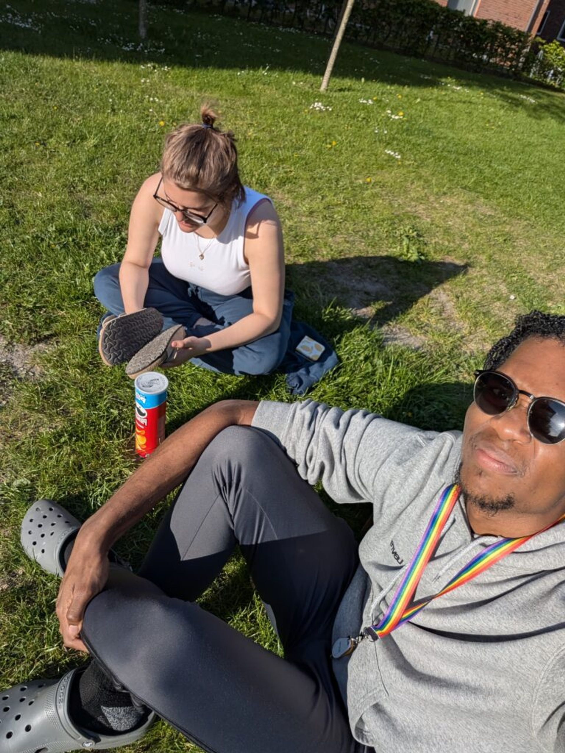 A selfie of Joshua and his friend Margot sitting in the grass in the sun.
