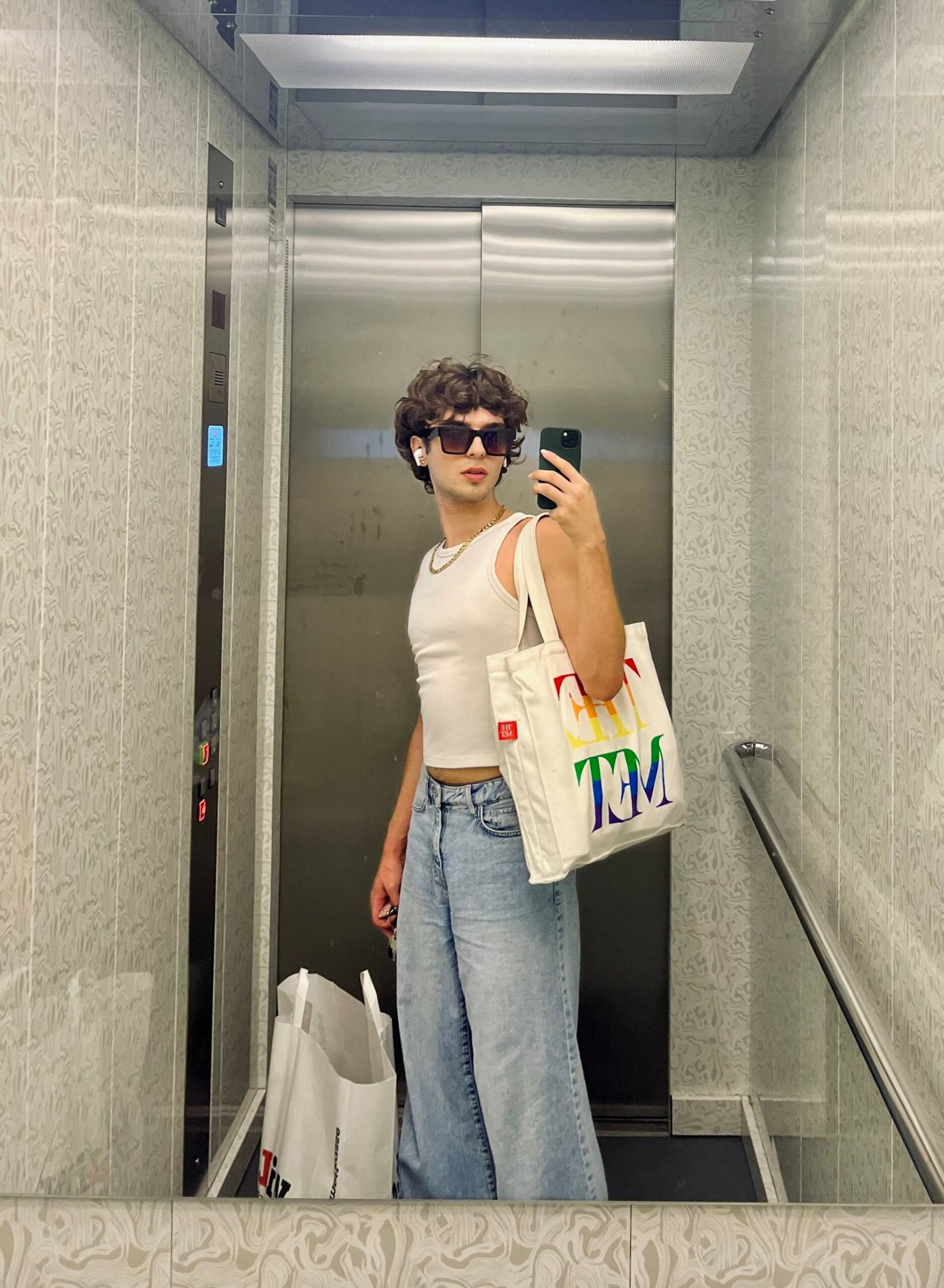 a mirror selfie of kiss with a tote bag in the elevator