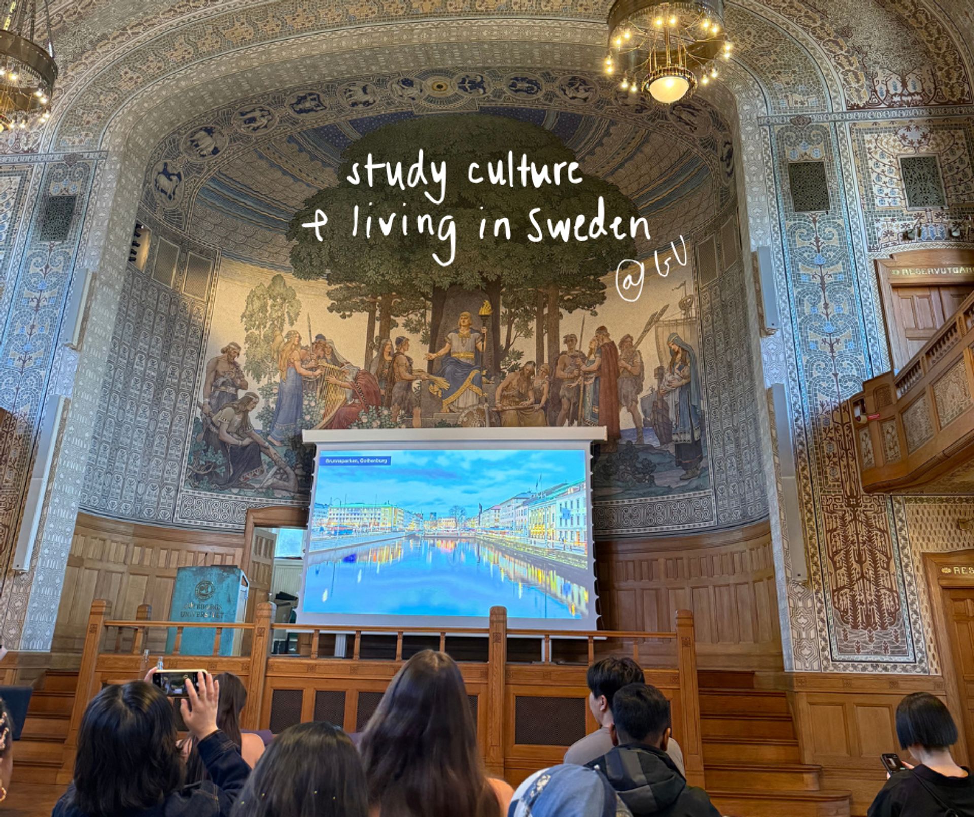 A mosaic wall and projector screen in Gothenburg University's main building. Handwritten text on the image reads study culture and living in Sweden at GU.