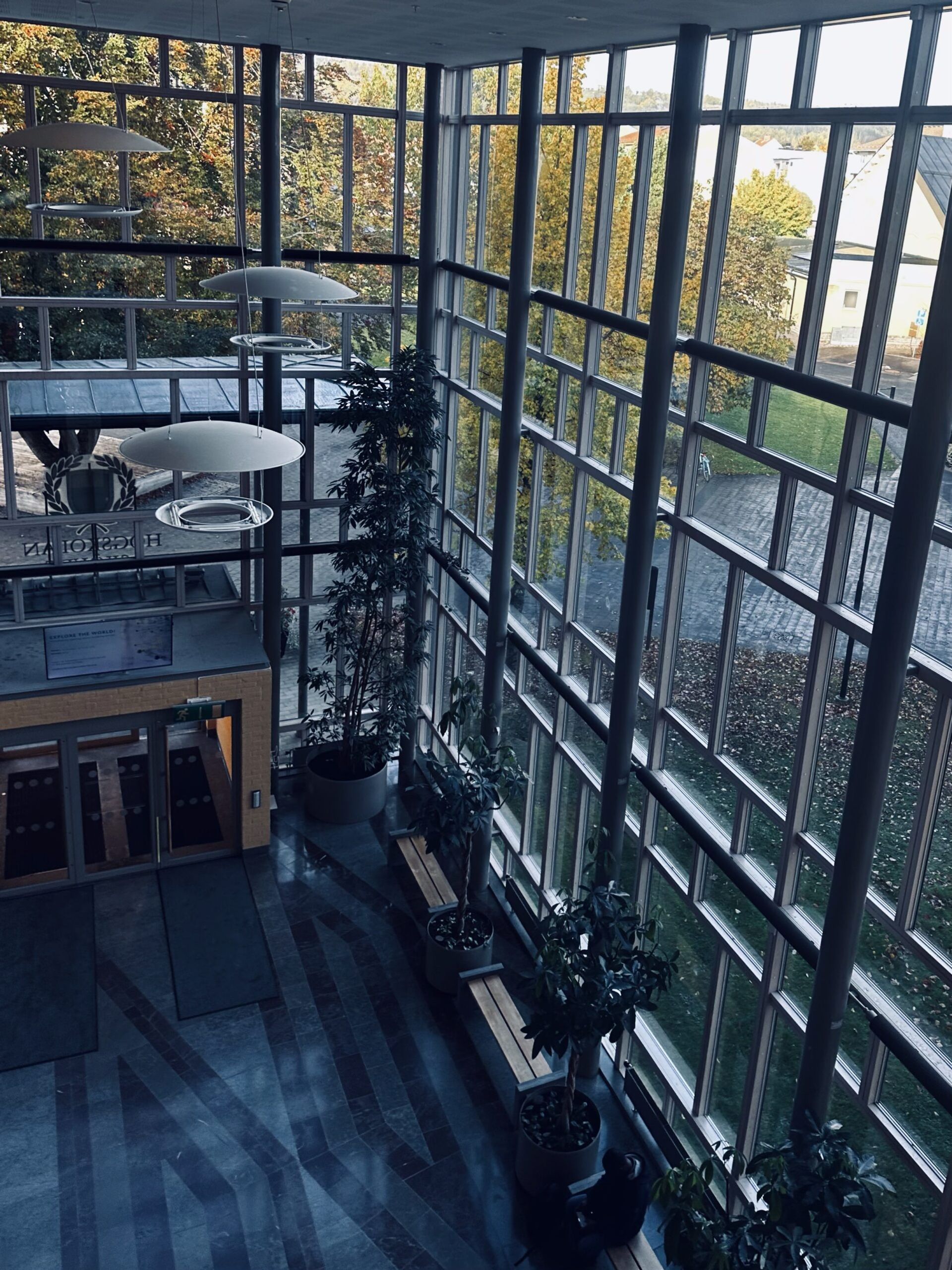 An inside of a building with multiple glass windows all the way up to the ceiling