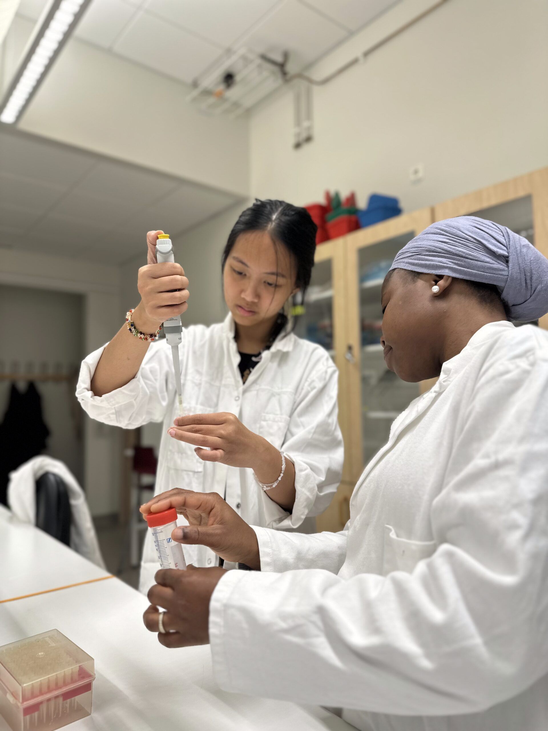 Two students in a lab pipetting