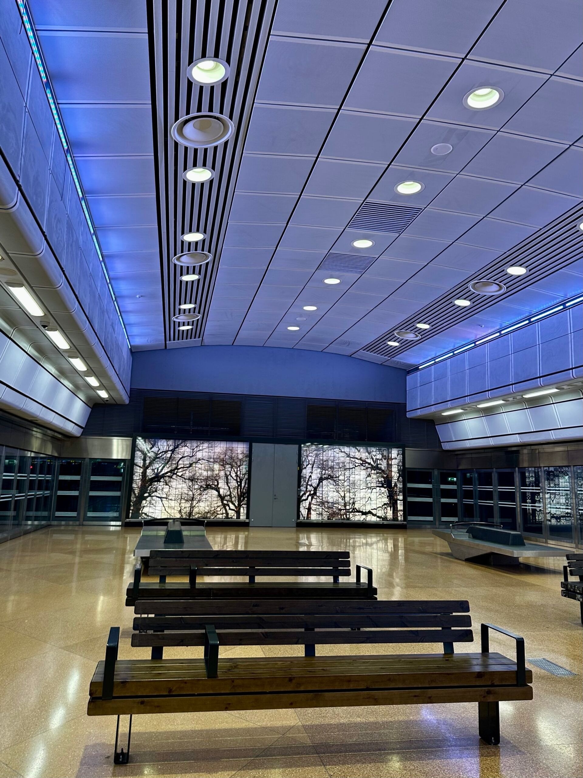 The interior of T-centralen in stockholm, showing benches and a blue ceiling