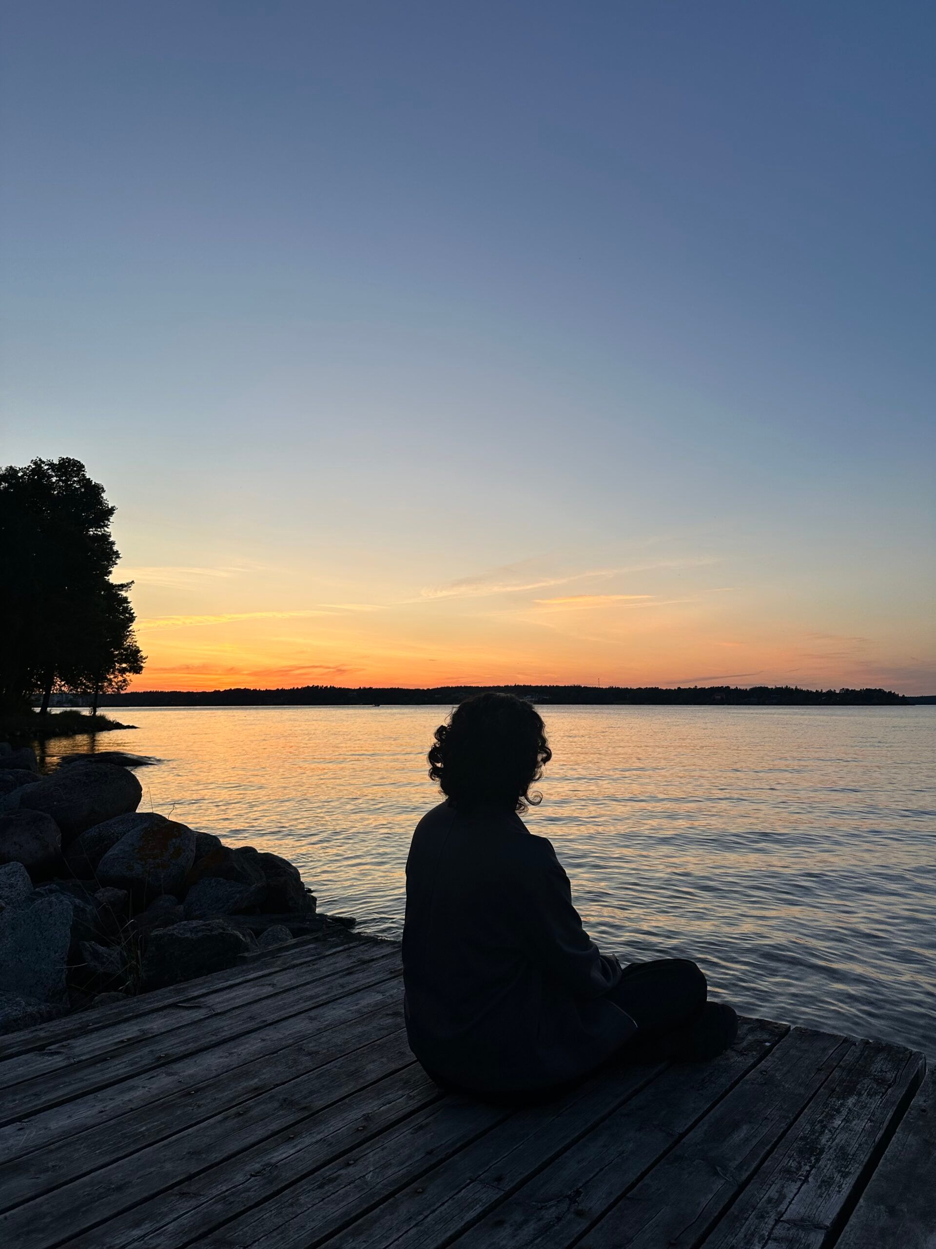 a figure facing their back and looking at the sunset
