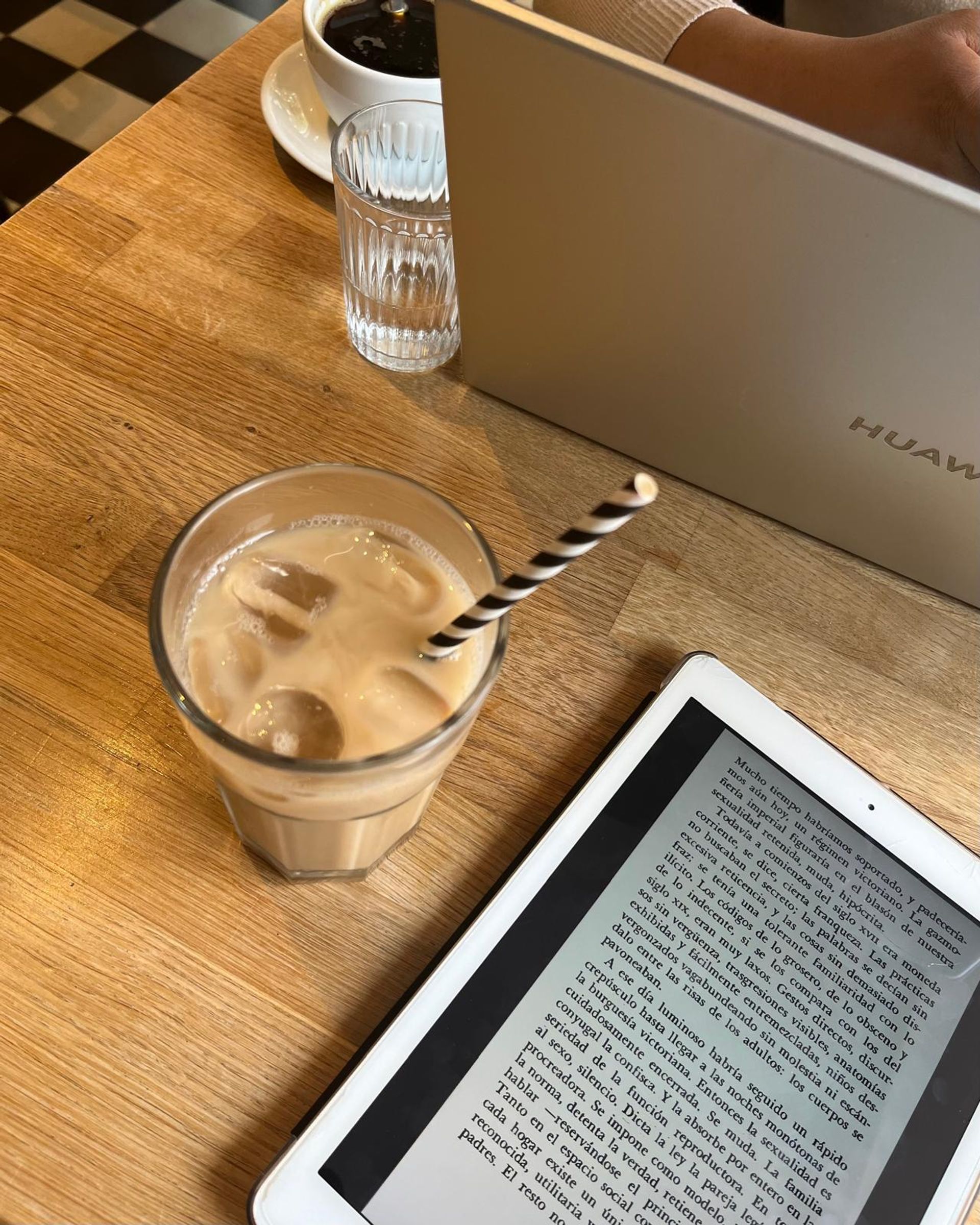 An Ipad and a coffee on a table of a cafe