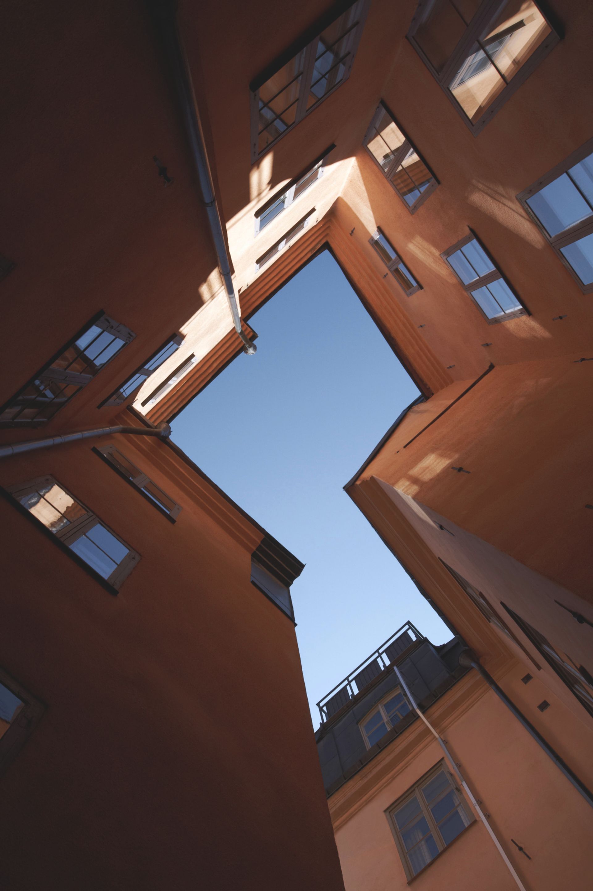 a view of the sky through tall old buildings in Gamlastan