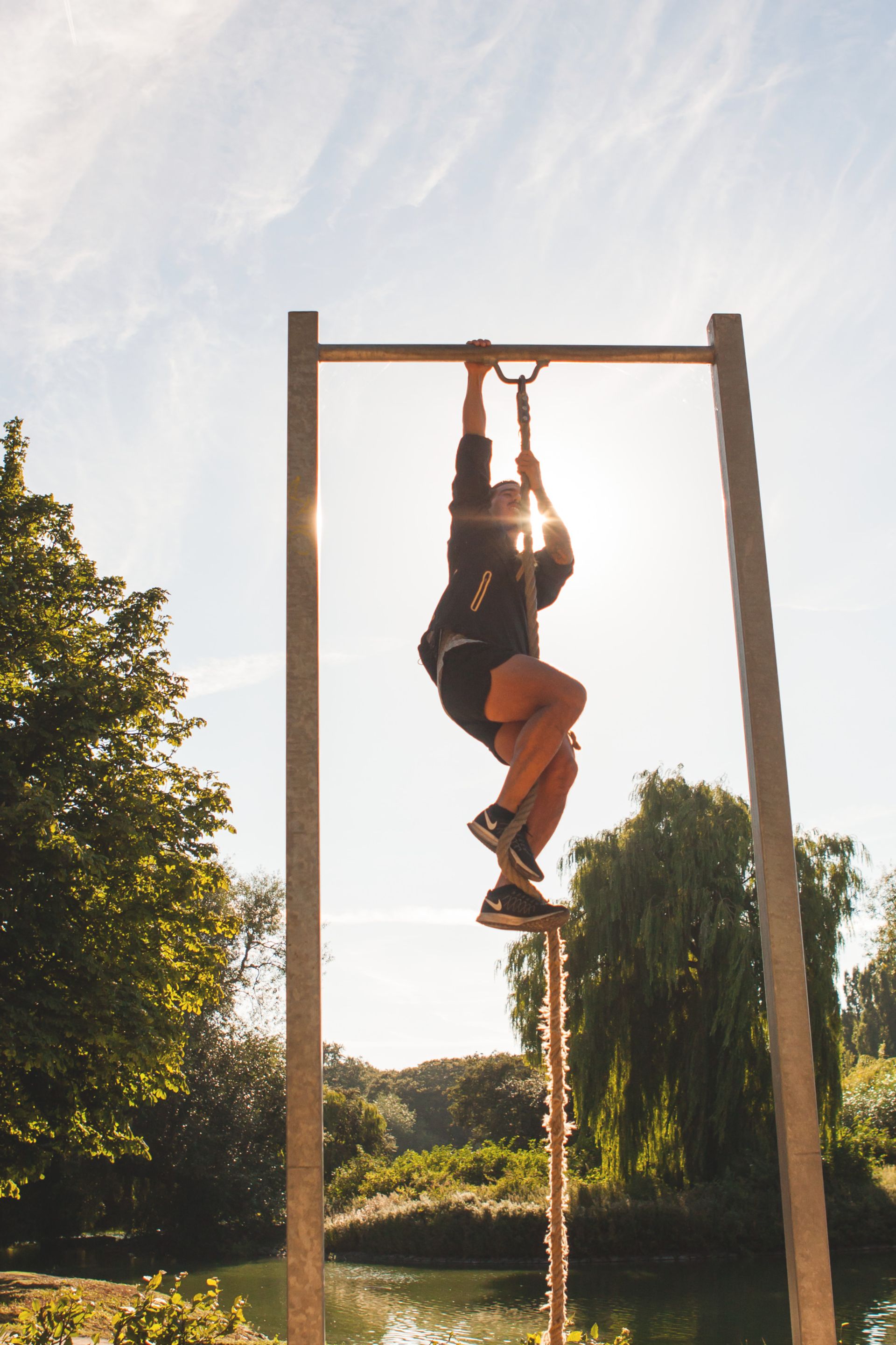A man climbing a rope at an outdoor gym