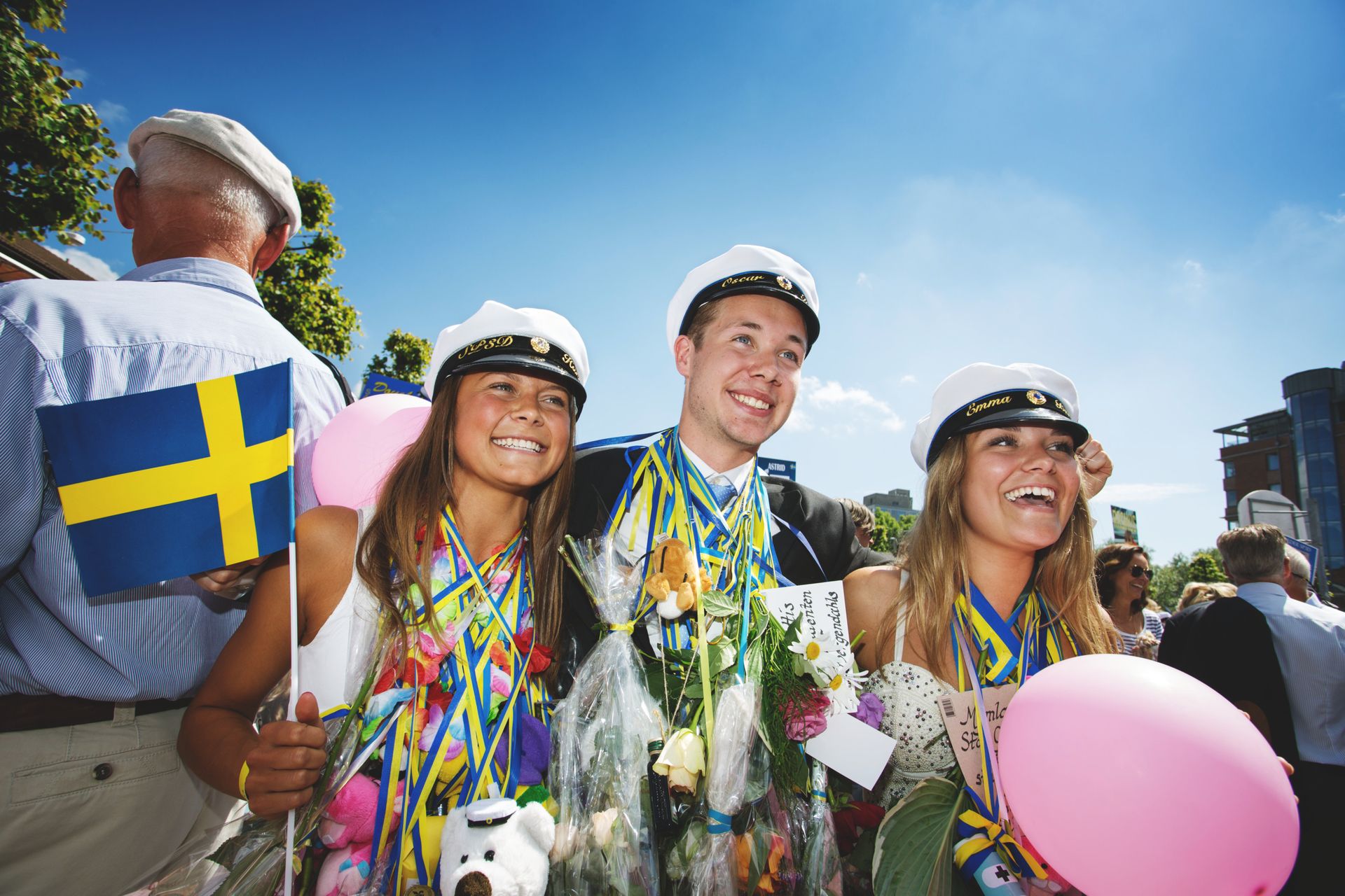Three graduating students posing for a photograph outdoors