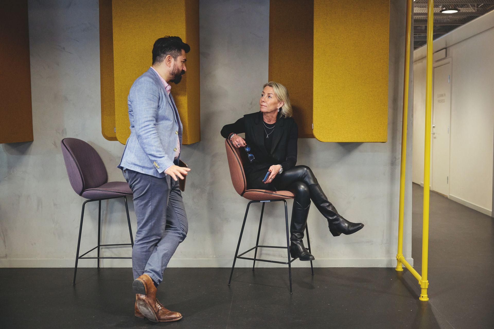 A man and woman talking in a casual office setting.