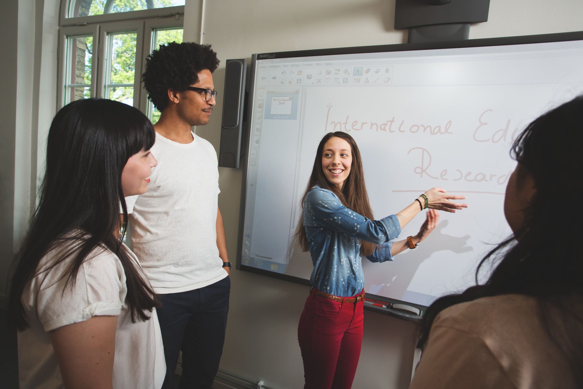A group of students near a screen discussing