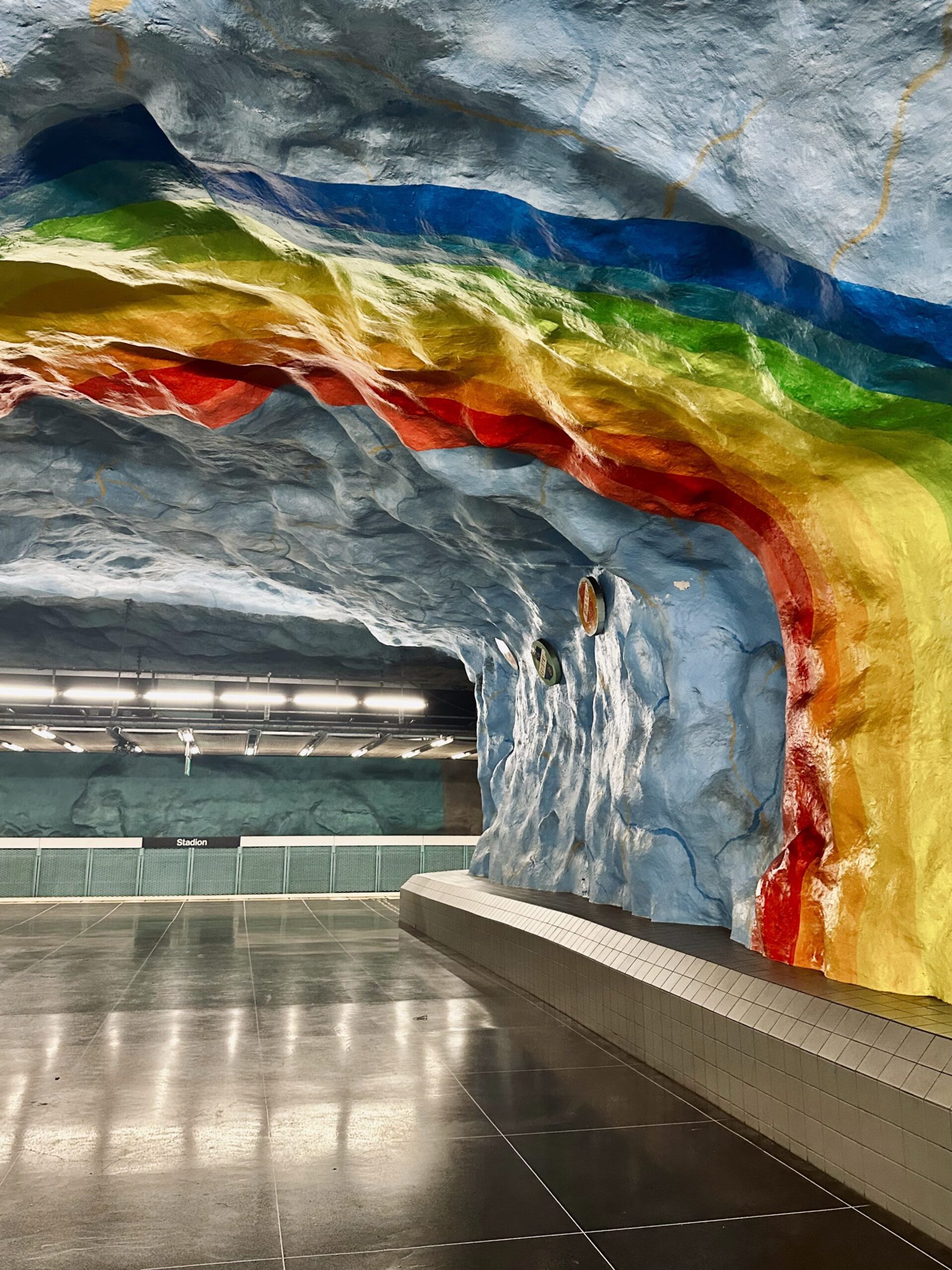 A stockholm Subway station with colorful artwork on the wall